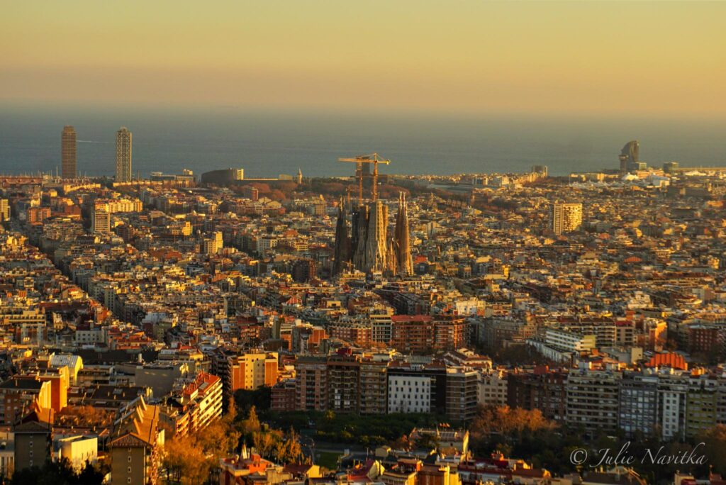 Image showing a panoramic view of the city of Barcelona at sunset. Choosing when to visit a big city can make a difference for the sustainability of your trip.