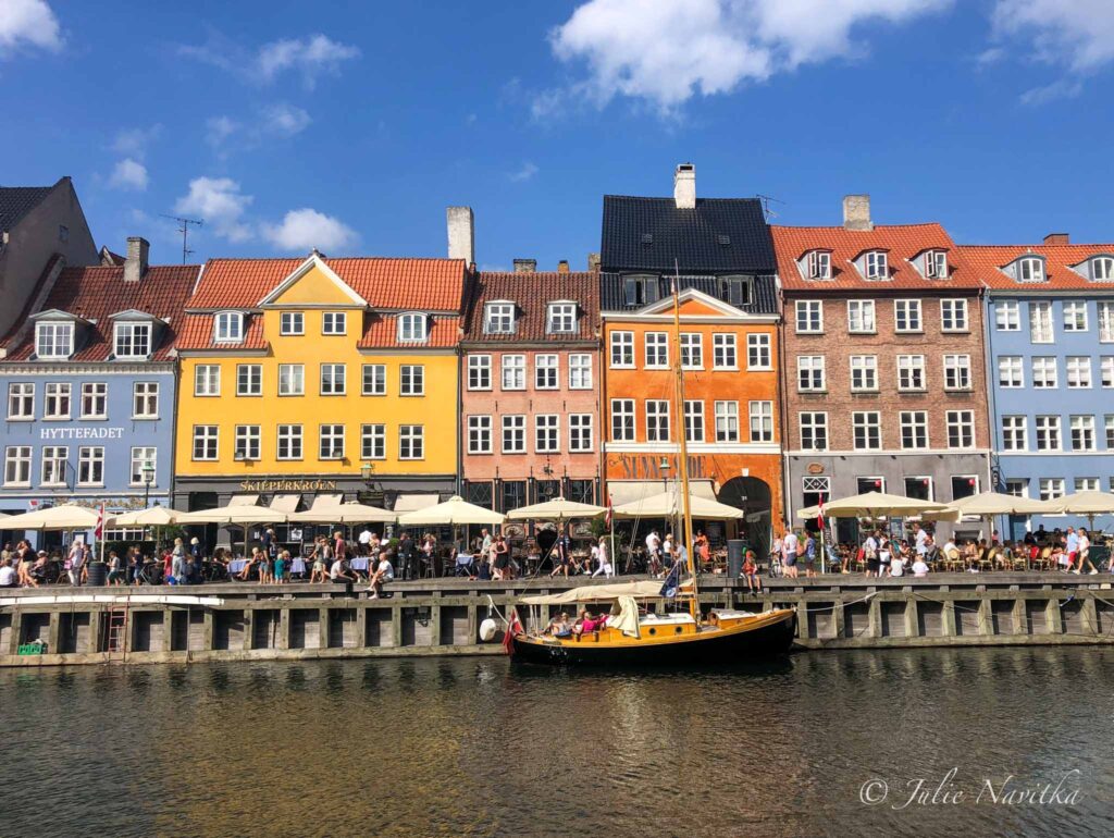 Image of classic architecture with waterway and boat in foreground in Copenhagen, Denmark.