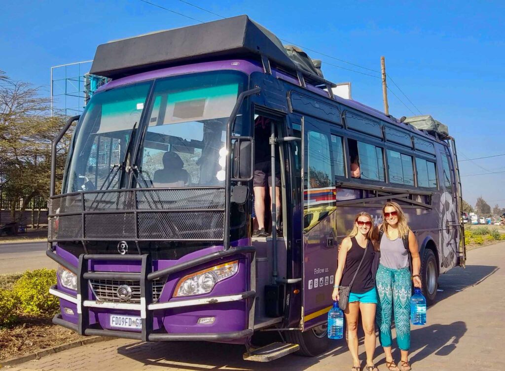 Image of two travelers about to board a motorcoach in Tanzania. Transportation choices play a major role in sustainable travel. 