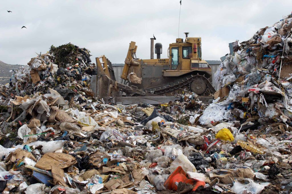 Image of a bulldozer pushing garbage around in a landfill.