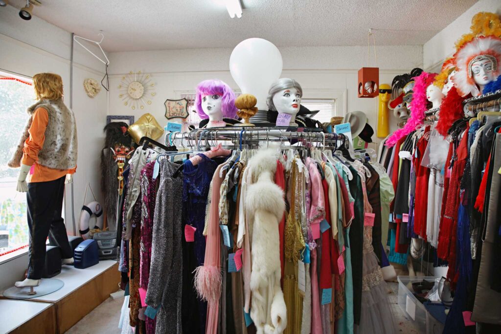 Image of a circular clothing rack in what appears to be a second hand/thrift store. Shopping second hand helps us lead a more sustainable lifestlyle.
