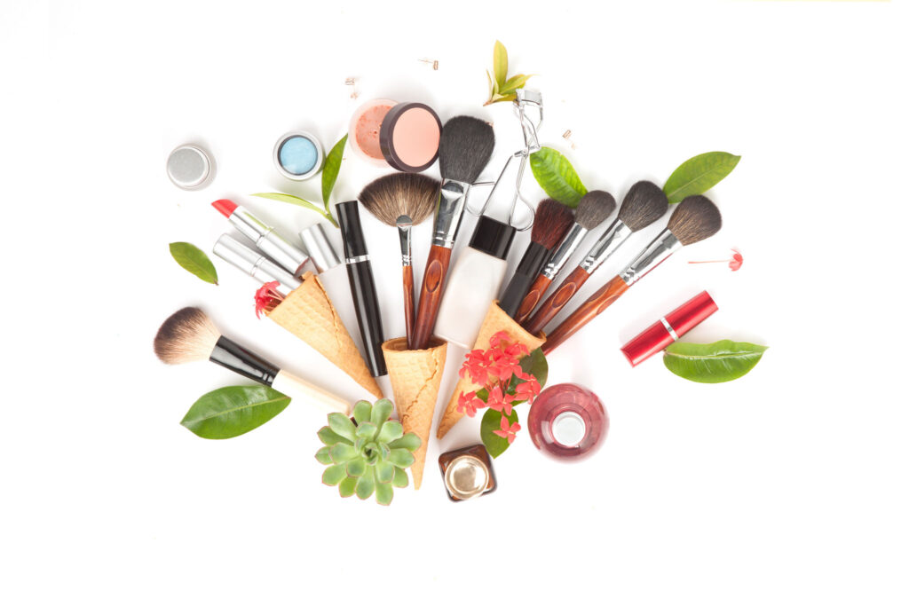 Image of a cosmetics and tools scattered among some leaves.