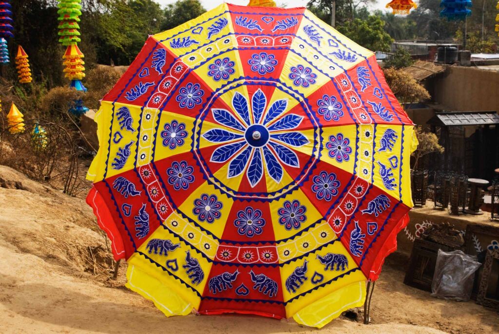 Top view image of a brightly coloured and patterned beach umbrella.