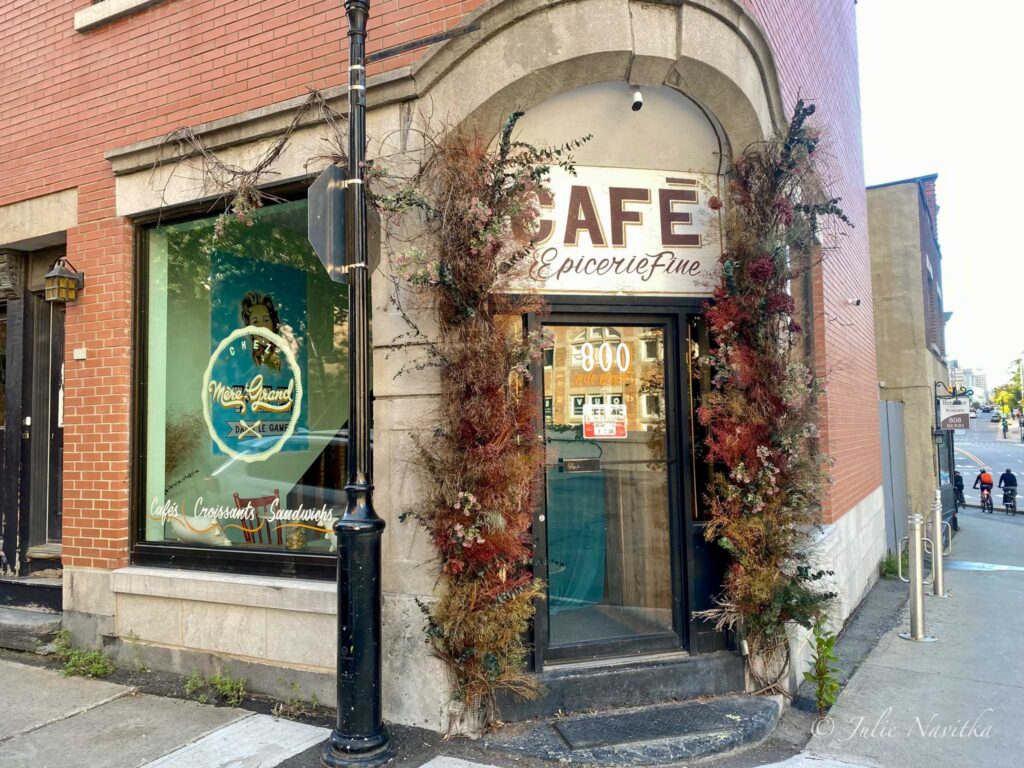 Image of the entrance of a cafe in a red brick building on a street corner in Montreal. Montreal is ranked 24th on the Arcadis Sustainable Cities Index 2022. 