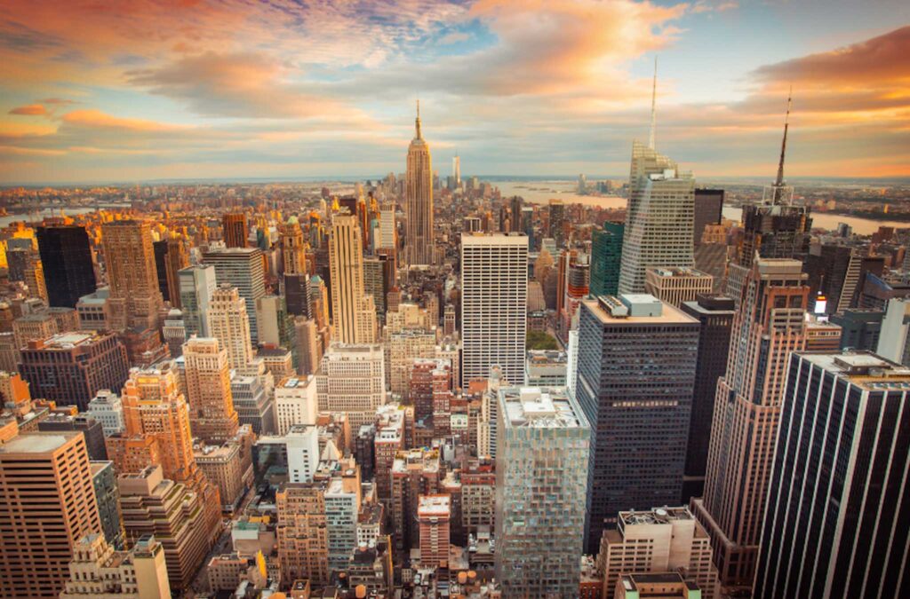 Image of a cityscape from above with a pastel sunset sky.