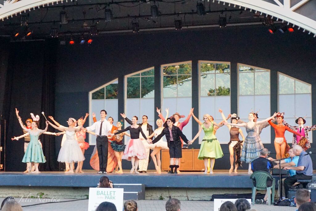 Image of an outdoor stage with many ballet dancers taking a bow. Hosting events and performances can help create a more sustainable park.