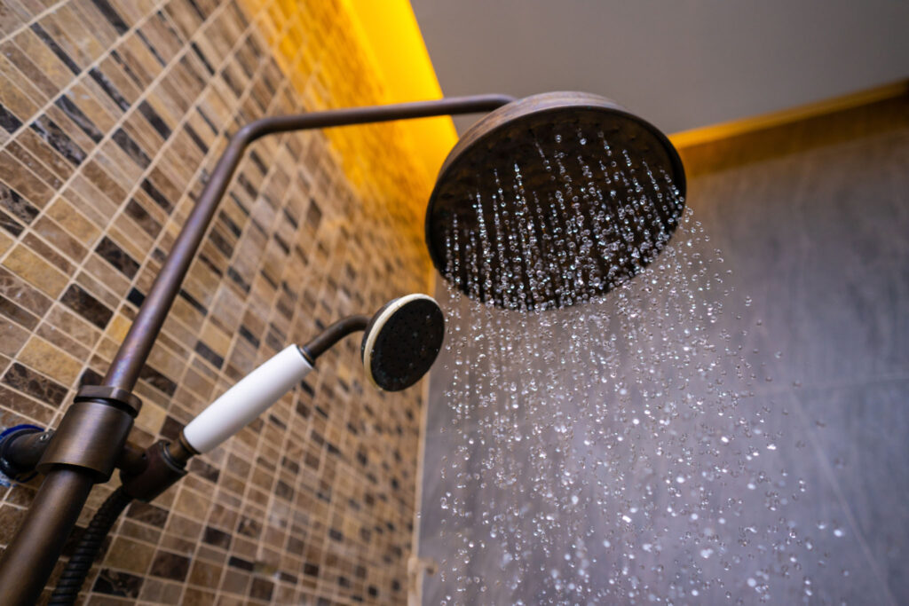 Image of water flowing out of a showerhead. Shortening your shower by just a few minutes can reduce water use by many gallons.