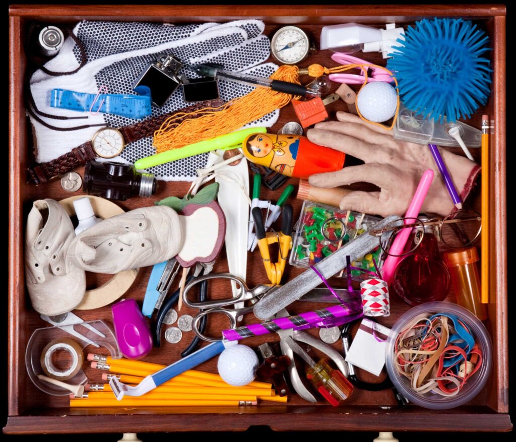 Bird's eye image of a "junk drawer" filled with an random array of items. Keeping an up-cycle box in your classroom to use for recycled projects can lead to a more green classroom.