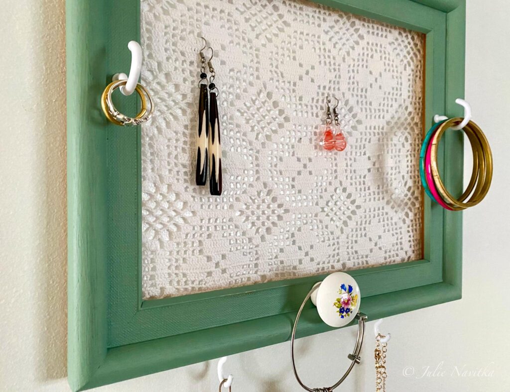 Image of a picture frame upcycled into a jewelry organizer using mistint paint and thrifted lace.