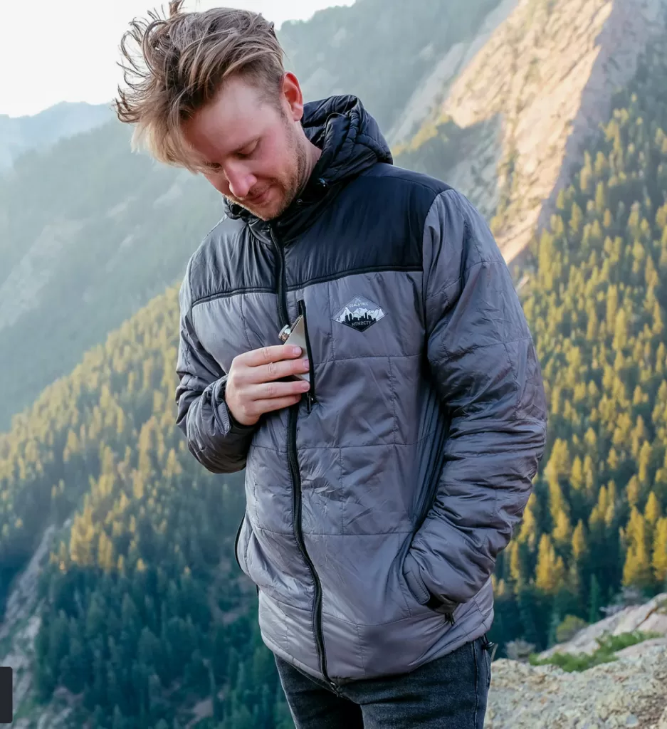 Image of a man wearing the Camper Hooded Jacket from Coalatree outdoors. Coala tree makes sustainable clothing for casual work and outdoor recreation.