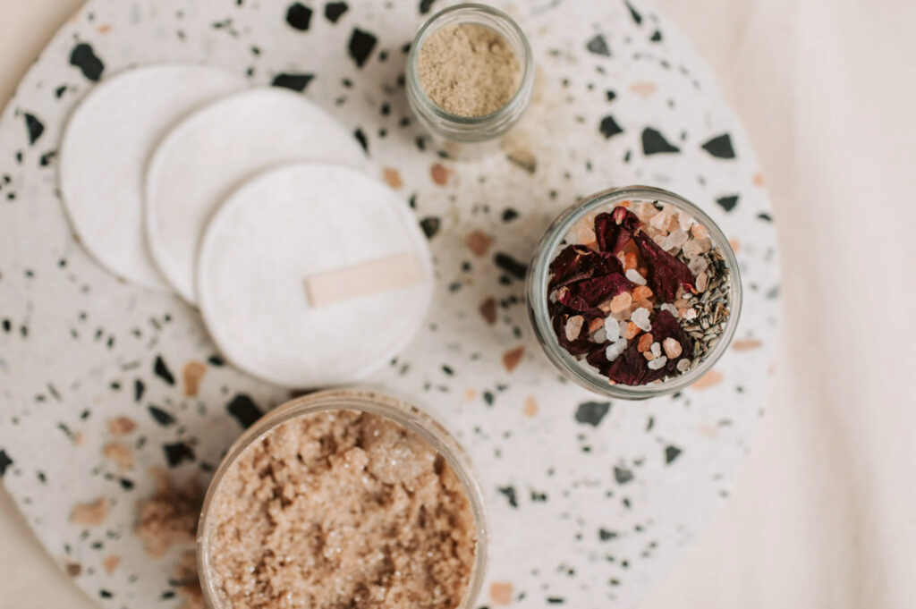 Image from above of a few small jars of exfoliating cosmetics. Many personal care products still contain microplastics that are harmful to the environment.