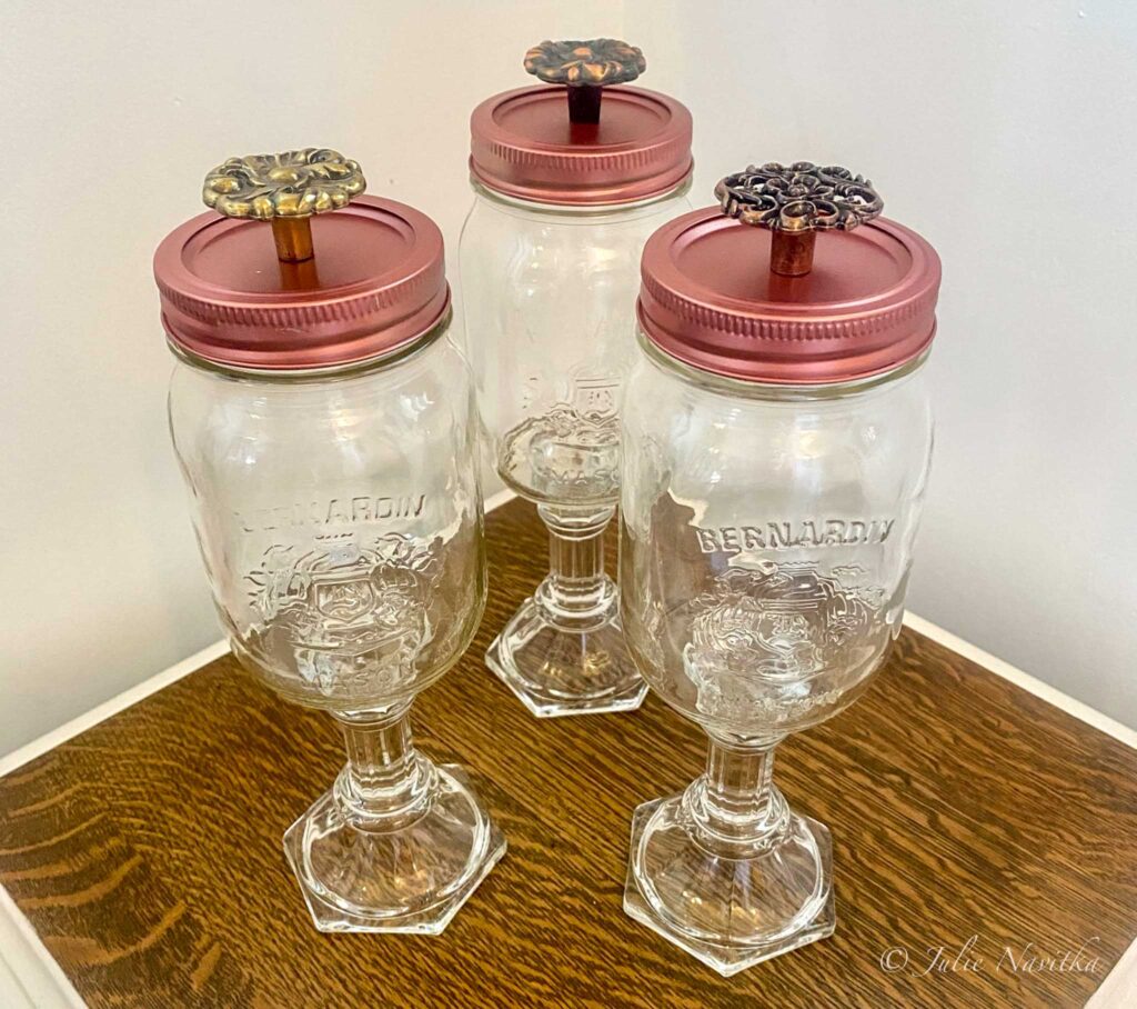 Image of three mason jars upcycled into a set of matching decorative storage containers. You can find millions of ideas for upcycling old household items into new, useful creations online.