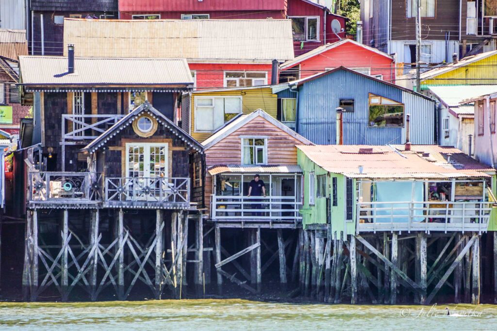 Image of palafitos (stilt houses) in Chiloe, Chile. Choosing accommodations owned by local people helps the economy.