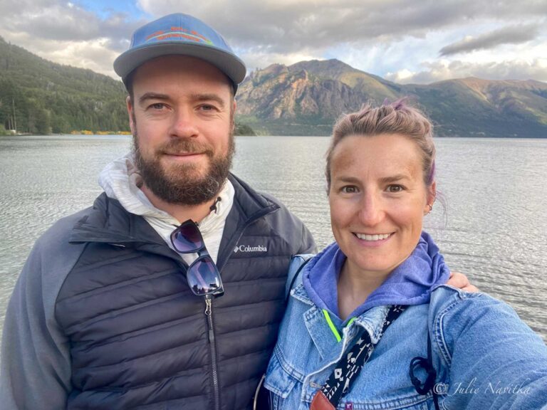 Image of author and partner in front of a lake with mountain background in Villa los Coihues, Argentina. Slomads are travellers who choose to travel slowly in order to reduce their environmental impact.