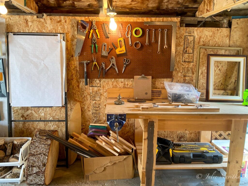 Image of a workbench in a home garage with tools and scrap materials and wood surrounding. Repairing or upcycling household objects rather than throwing them away can help you lead a more sustainable lifestyle.