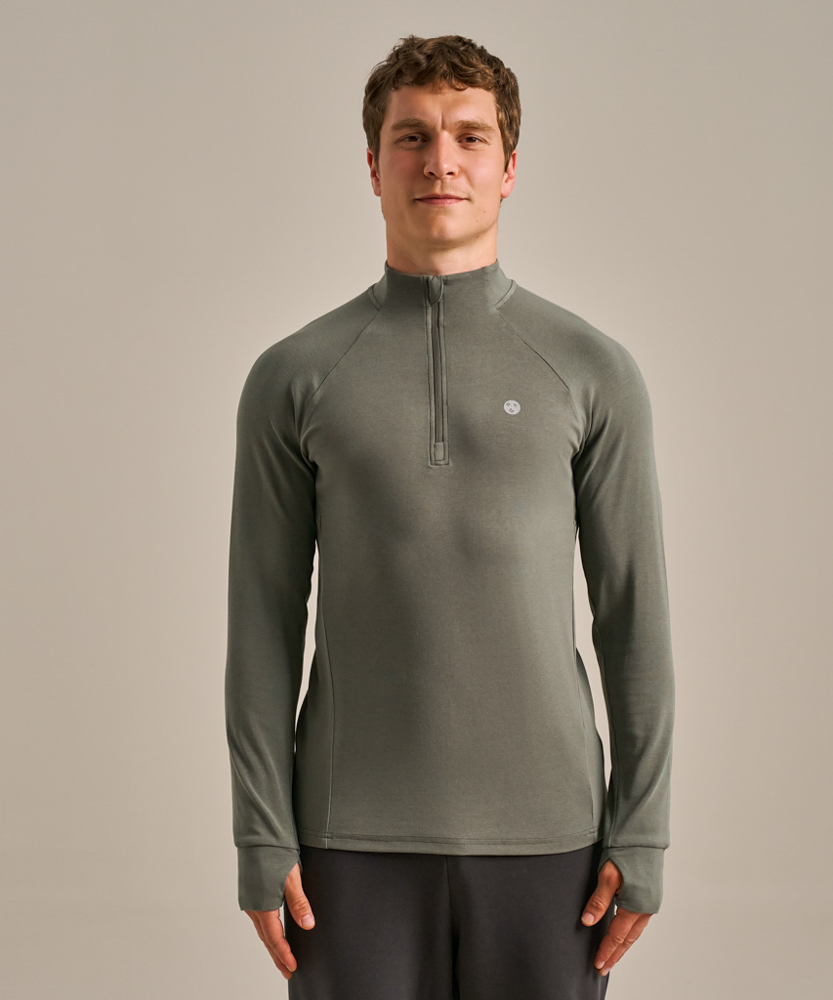 A model wears the men's Active Luxe Quarter Zip Baselayer from BAM. 