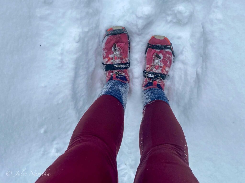Image of a pair of hiking shoes taken from above by someone wearing them in the snow.
