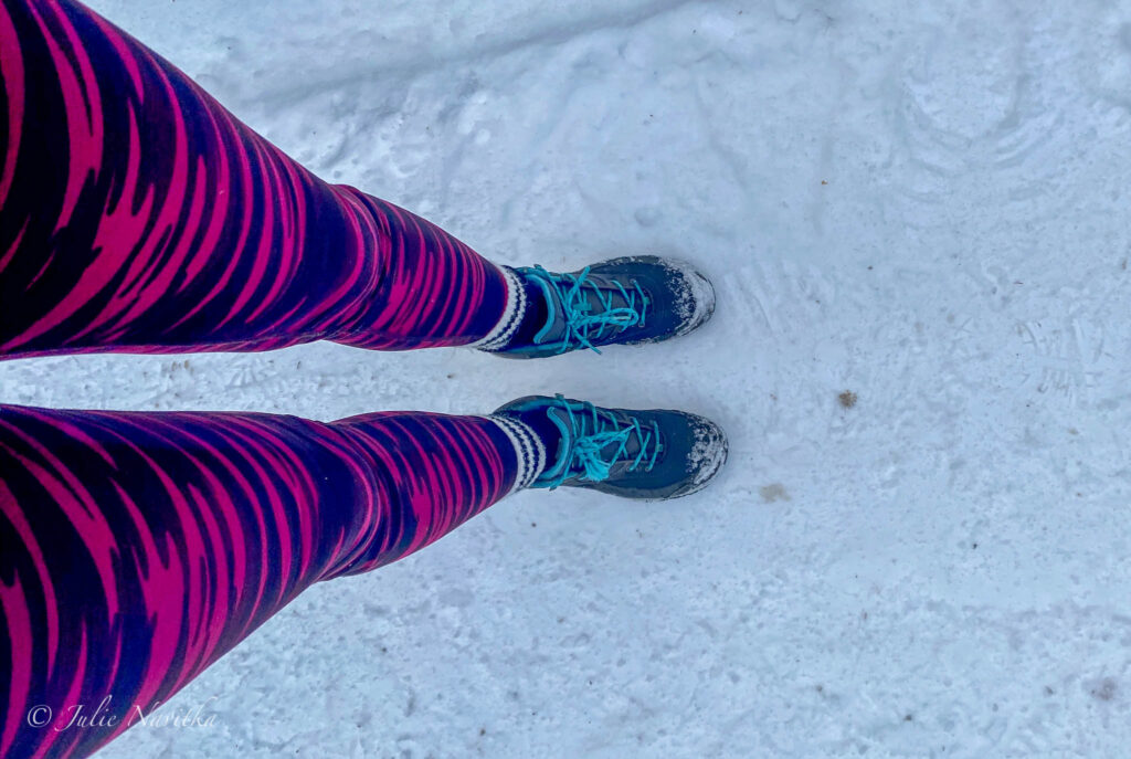 Image taken from the view of a hiker of their boots in the snow.