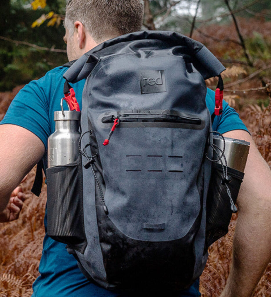 Image of a model wearing the Roll Top Waterproof Backpack 30L by Red