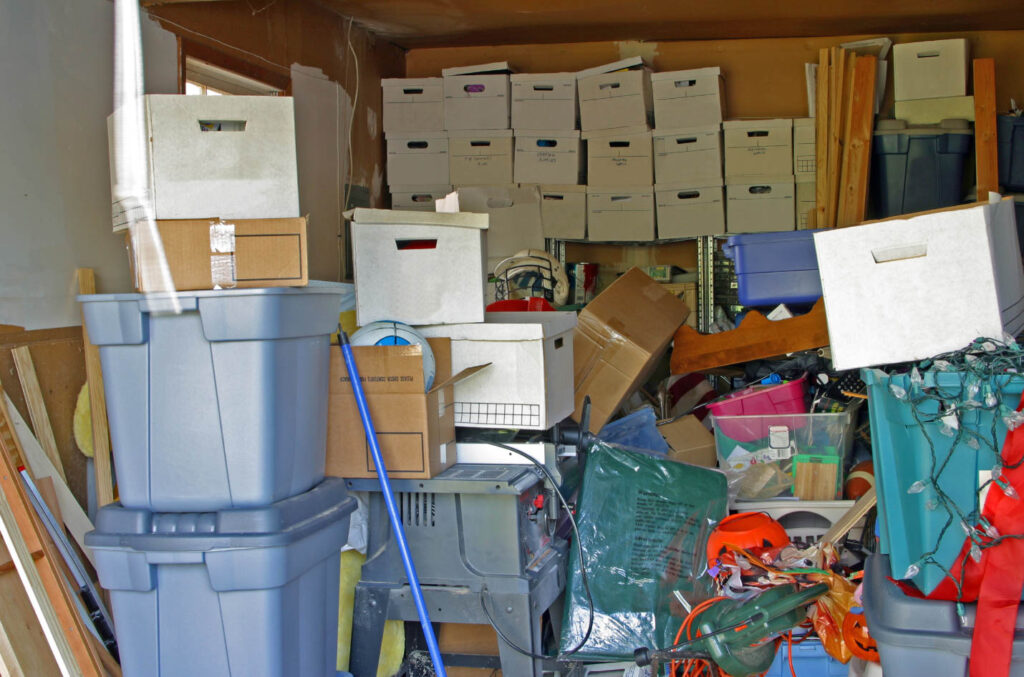 Image of a garage cluttered with items, boxes and bins.