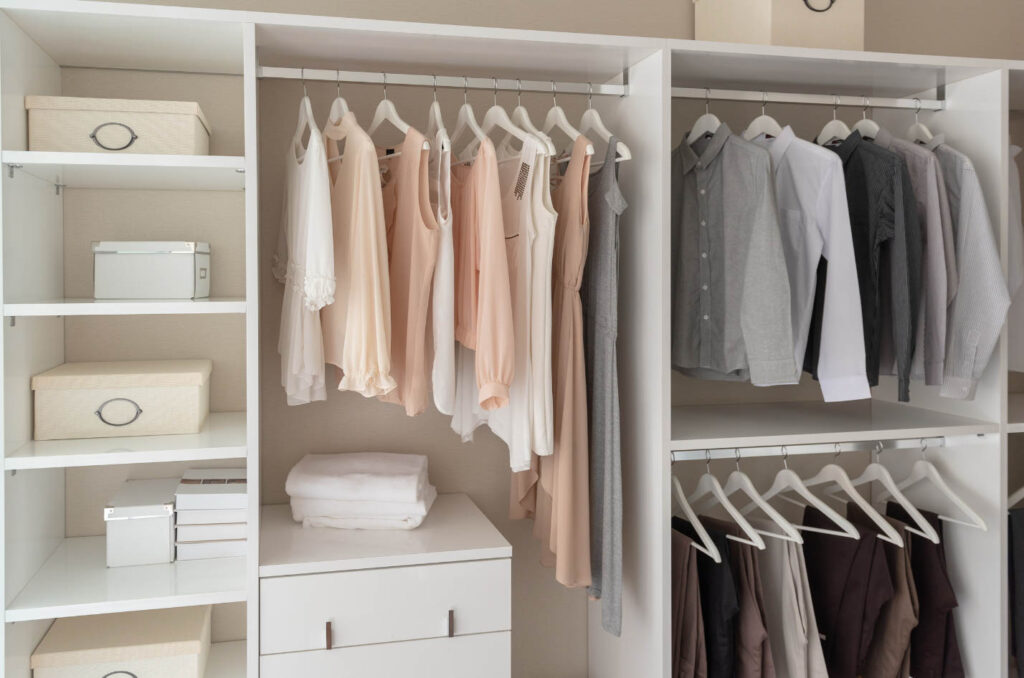 Image of a very organized closet with minimal clothing inside. 