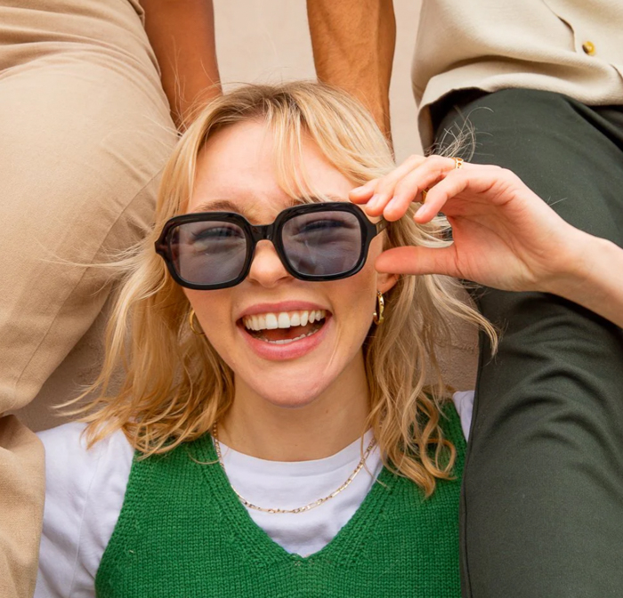 Image of a laughing woman wearing the Montenegro Squares Sunglasses by Pela Case.