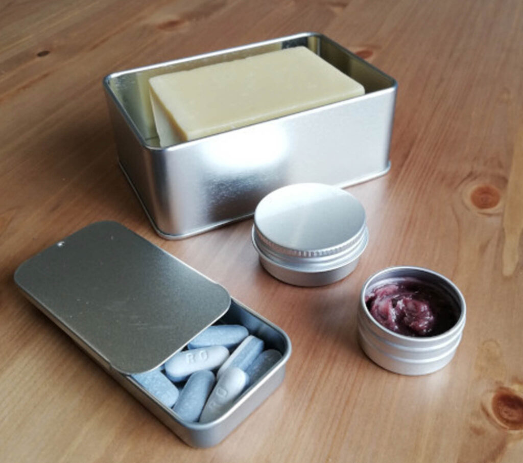 Image of four pieces of the tin travel kit without plastic - pack your sustainable travel toiletries safely and securely in these!