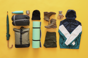 Image of a variety of camping gear items on a yellow background.