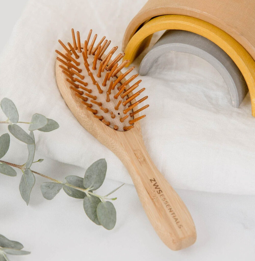 Image of the mini bamboo hair brush from zero waste store. Sustainable toiletries are made from eco-friendly materials.
