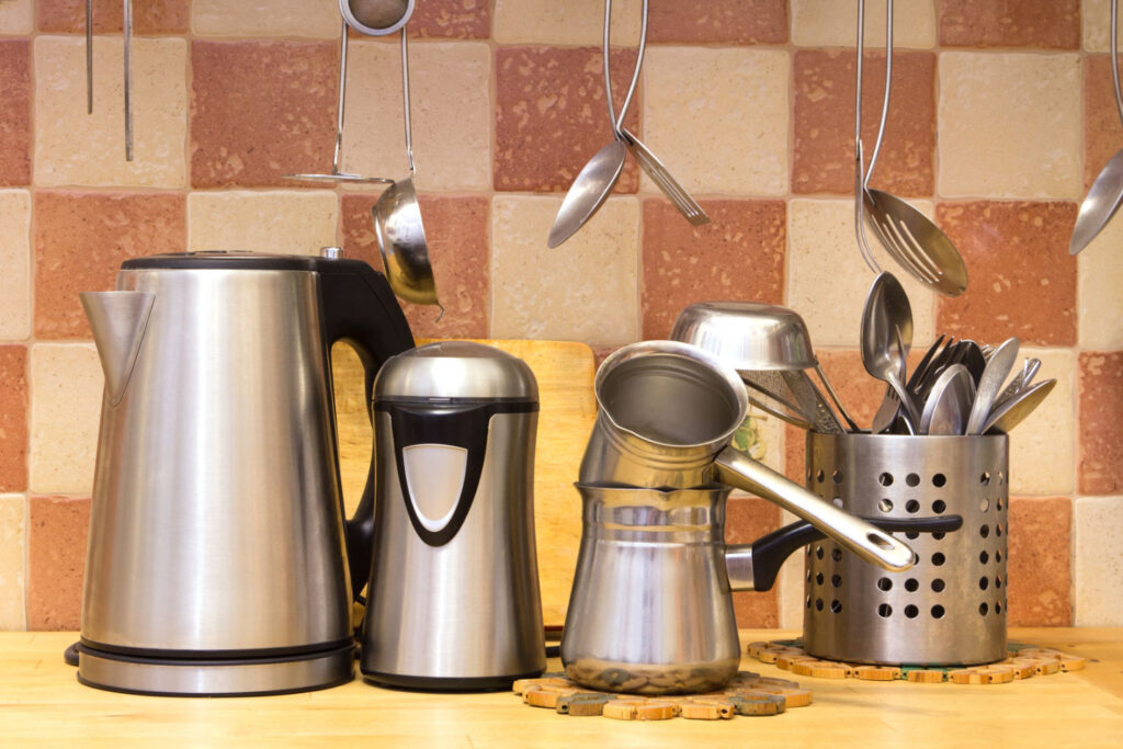 Image of some metal kitchen wares on a counter. Purchasing items made from durable materials can help you live more sustainably on a budget.