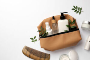 Image of a travel toiletries bag with various items inside and around.