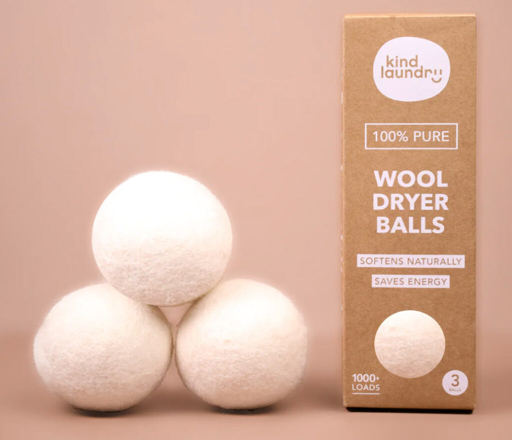 Image of three wool dryer balls from Kind Laundry beside the recyclable cardboard packaging.