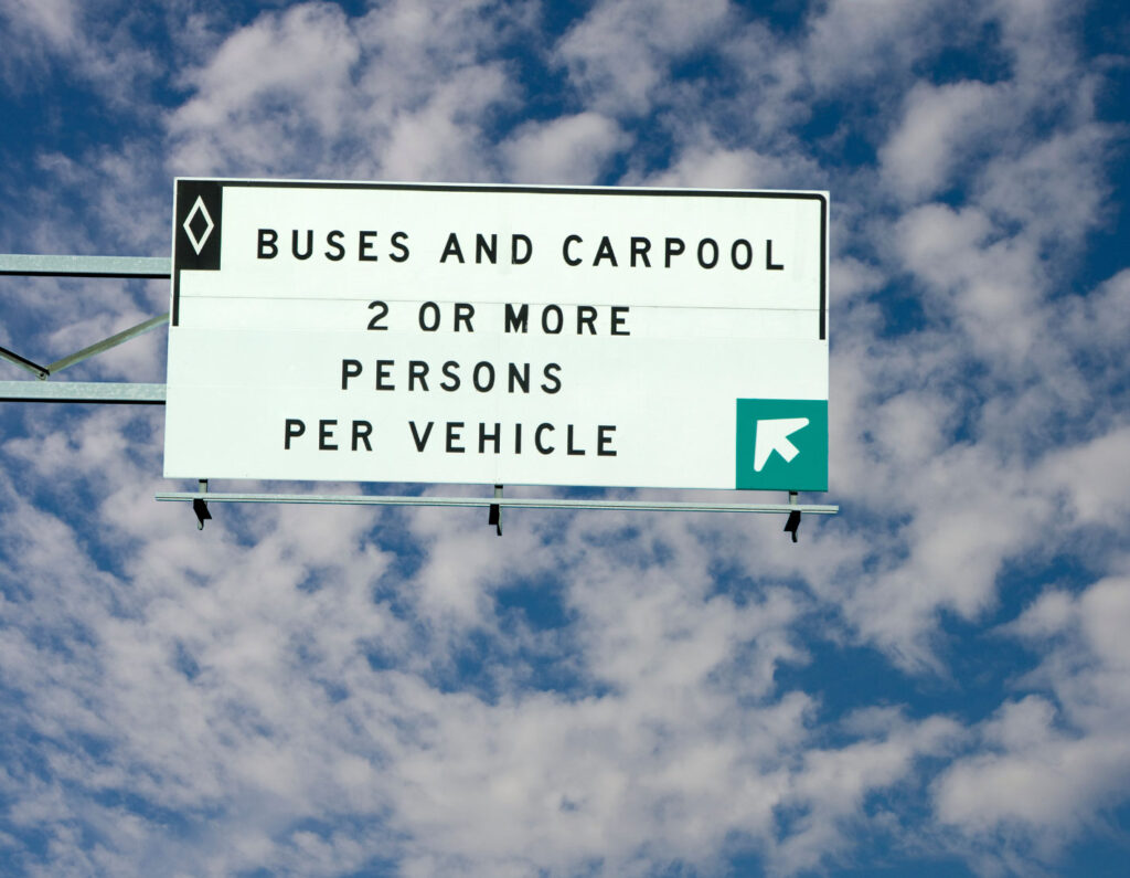 Image of an overhead highway sign reading "Buses and Carpool 2 or more persons per vehicle"