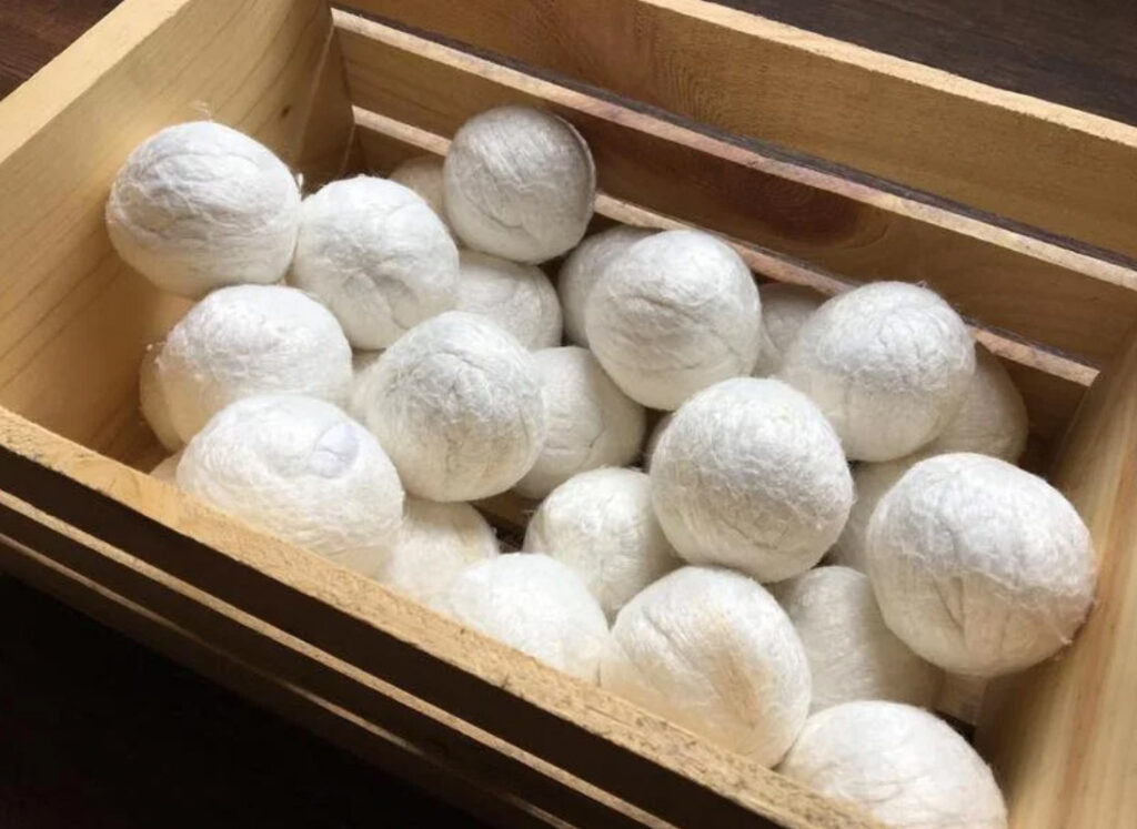 Image of many vegan bamboo dryer balls by Buddha Bunz in an open wooden crate.