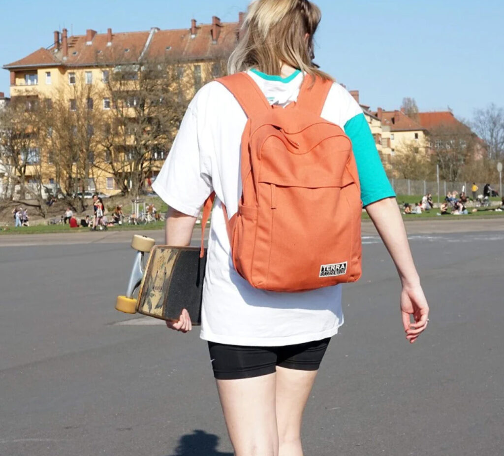 Image of a student walking to school wearing the Earth Backpack by Terra Thread. Carry all your earth-friendly and sustainable school supplies in an eco-friendly backpack!