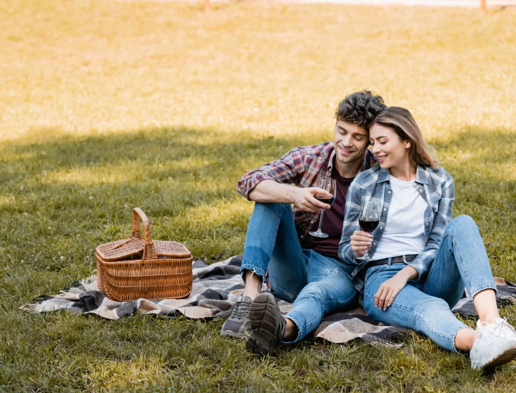 Image of a young couple enjoying an outdoor picnic on the grass. 