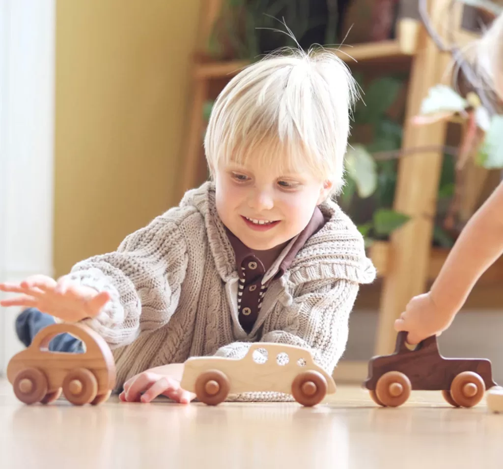 Image of a young child playing with handmade wooden toys by Smiling Tree Toys.