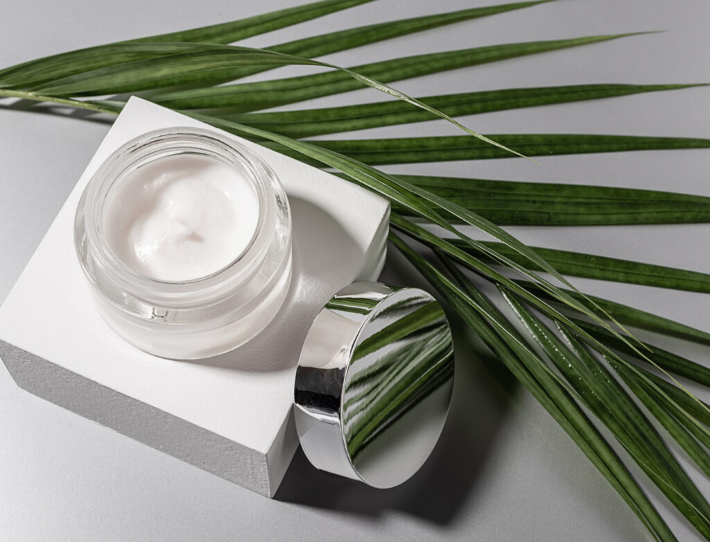 Image of a jar of lotion with a palm frond taken from above. Do you know the difference between cruelty-free and vegan beauty?