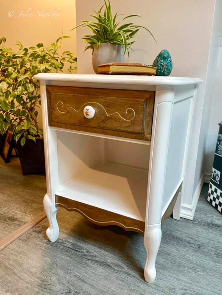 Image of a refinished vintage end table with a plant, book, and small ceramic bird sitting on top.