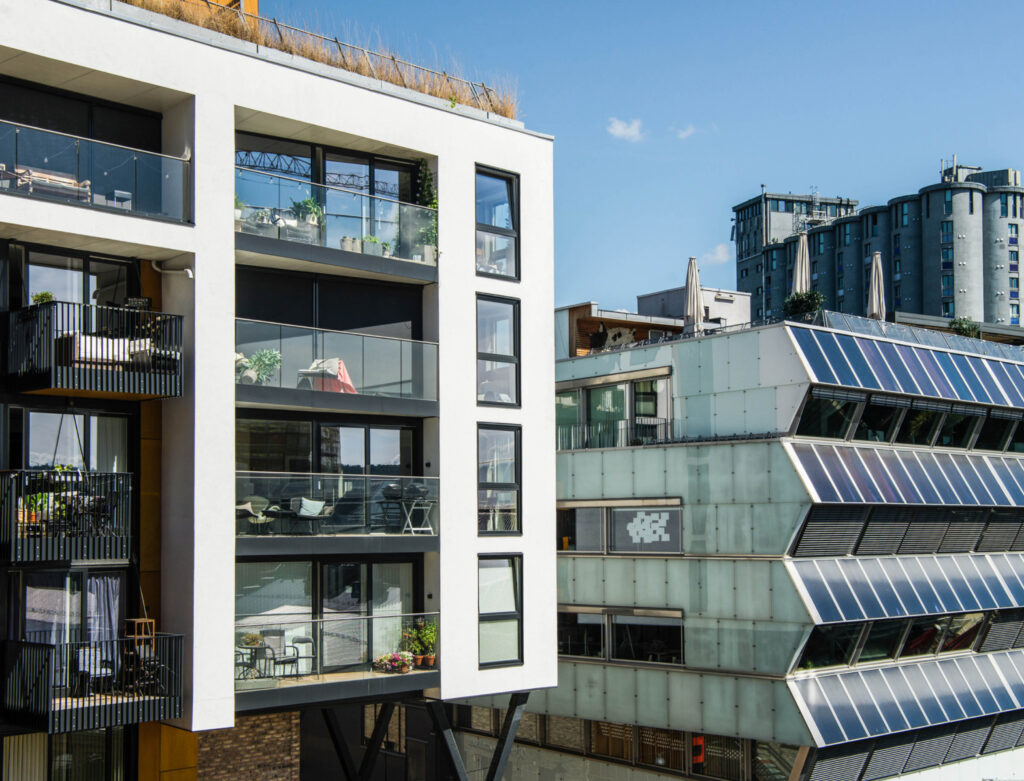 Image of two side by side buildings with solar panels and a rooftop garden. Some eco luxury hotels use renewable energy sources and grow their own organic food to use in their kitchen.