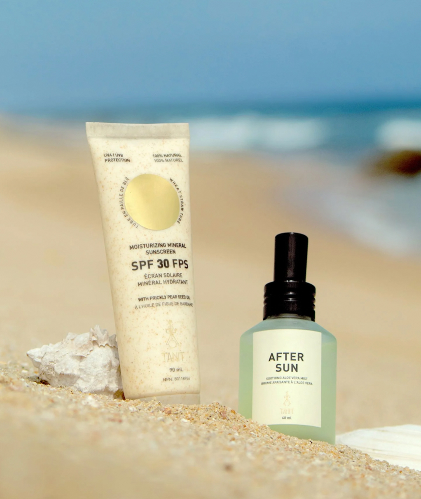 Image of Tanit's all natural mineral sunscreen and after sun care in the sand at the ocean.