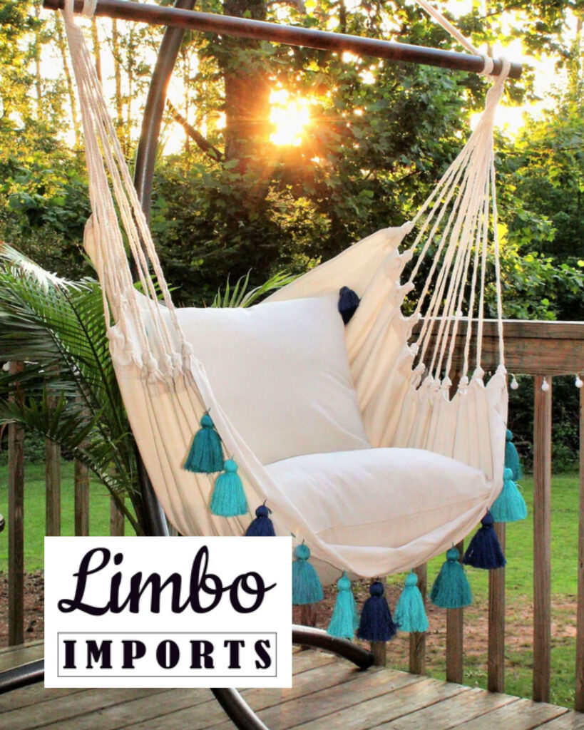 Image of a hammock chair made by eco-friendly brand Limbo Imports hanging on a deck with the sun shining through the trees behind it.
