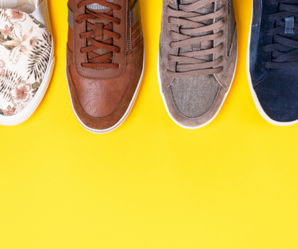 Image of four single shoes taken from above on a bright yellow background. Be careful, high end shoe brands and luxury shoe brands don't necessarily make the most durable sneakers or sustainable footwear.