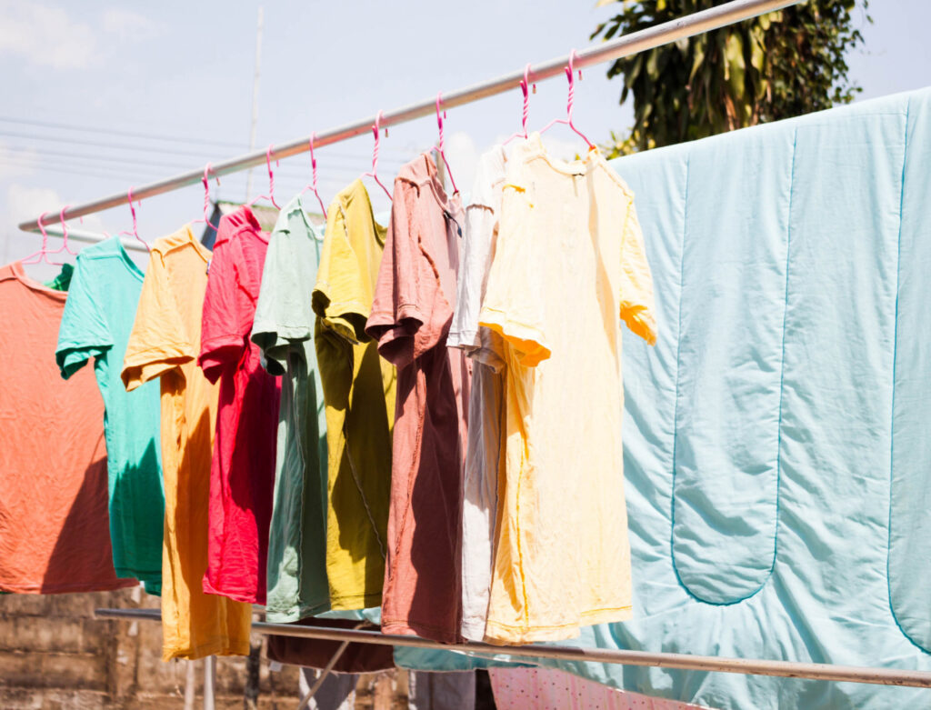 Image of a row of t-shirts hanging on a clothesline to dry.