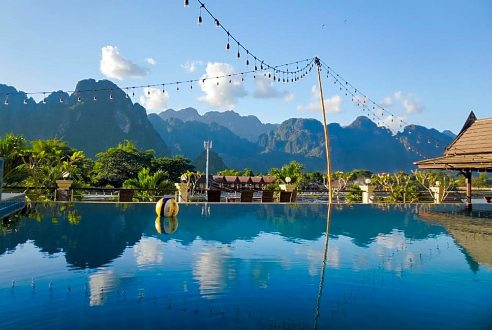 Image of the pool with mountains in the background at Silver Naga Hotel, an eco-friendly accommodation in Vang Vieng, Laos.